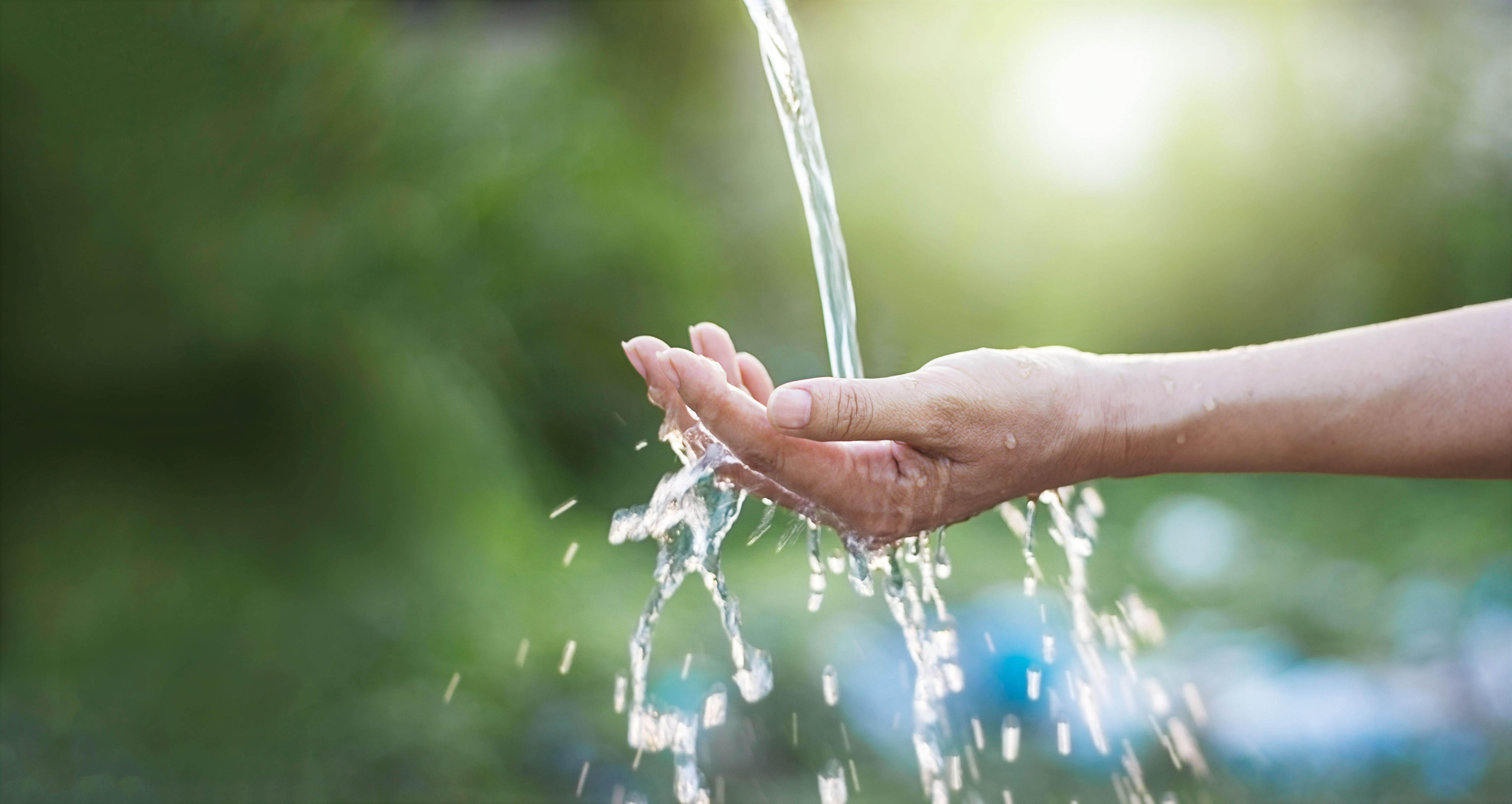 green background hand catching water flow